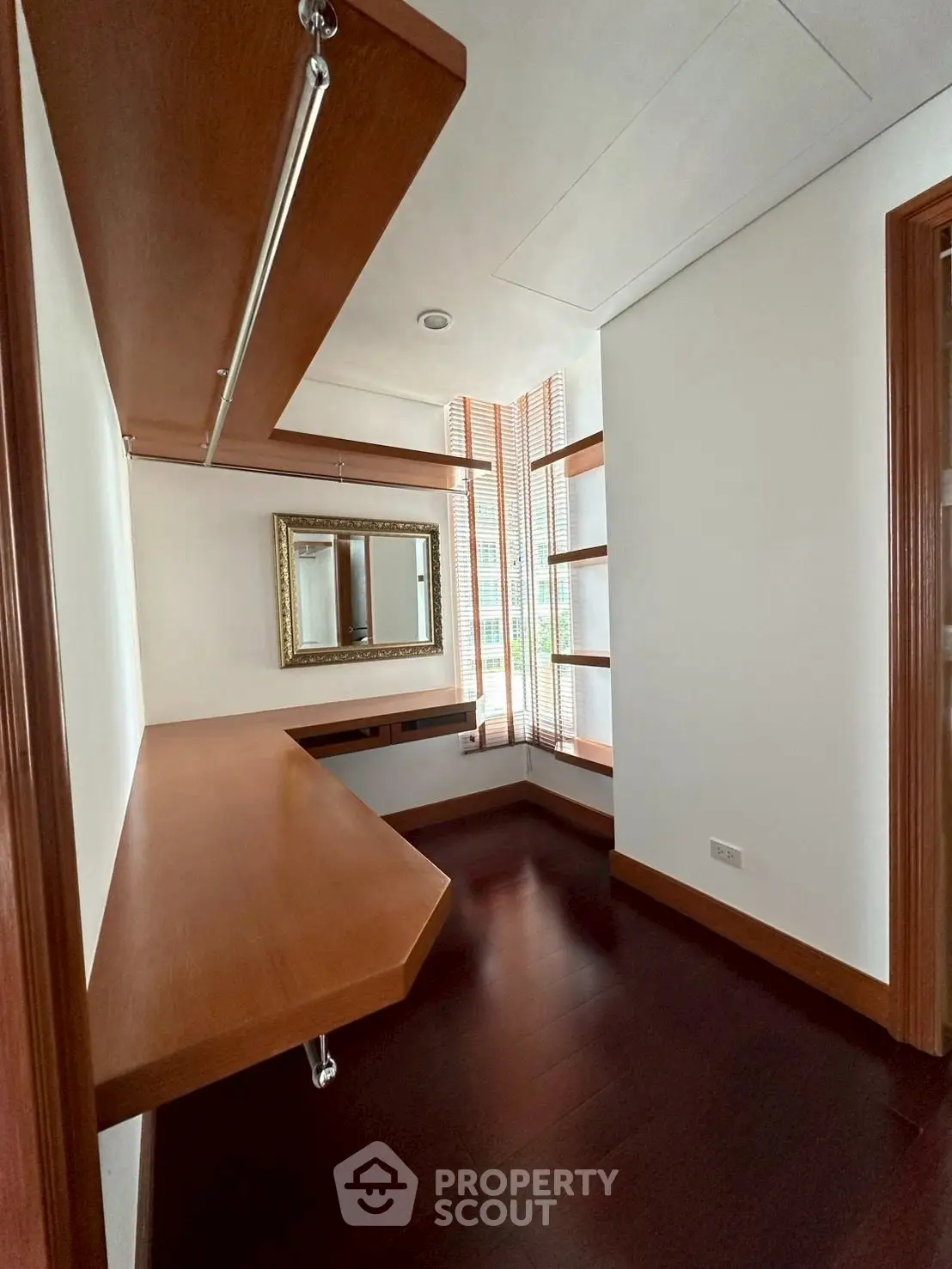 Spacious walk-in closet with wooden shelves and natural light