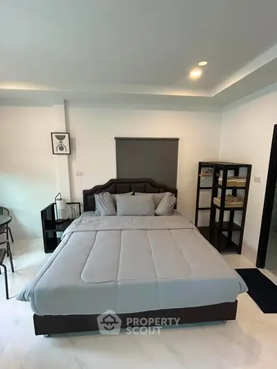 Modern bedroom with stylish decor and cozy ambiance, featuring a comfortable bed and sleek shelving.