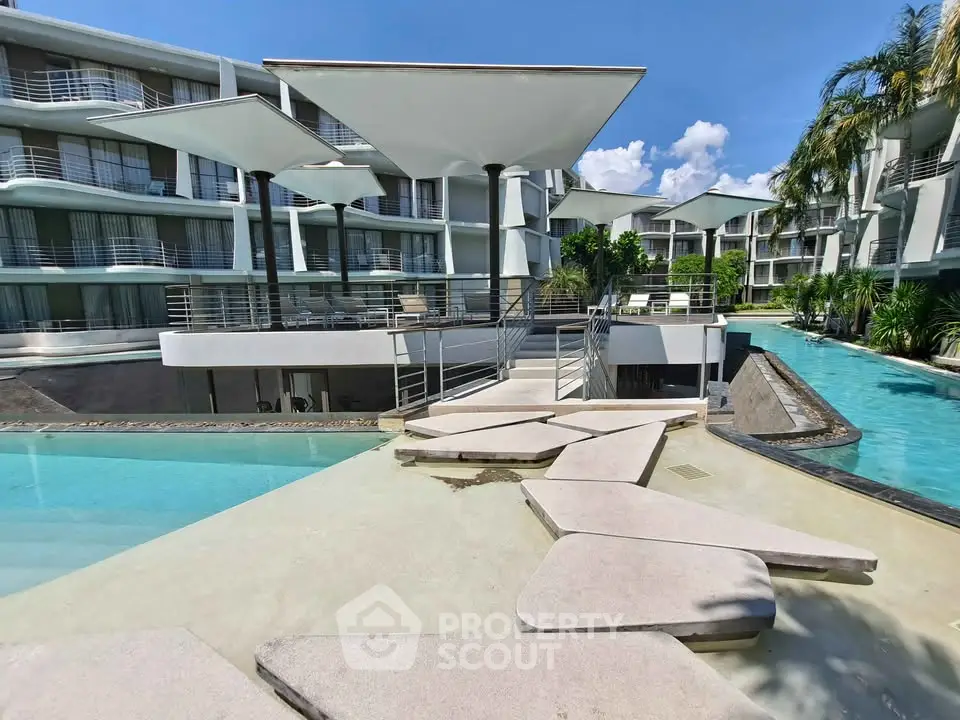 Luxurious modern apartment complex with stunning pool and unique architecture.