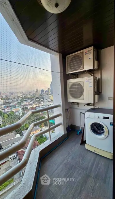 High-rise balcony with city view, featuring washing machine and air conditioning units.