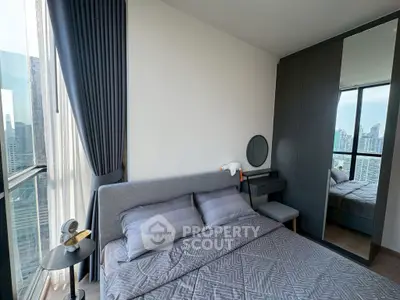 Modern bedroom with city view, featuring sleek furniture and floor-to-ceiling windows for natural light.