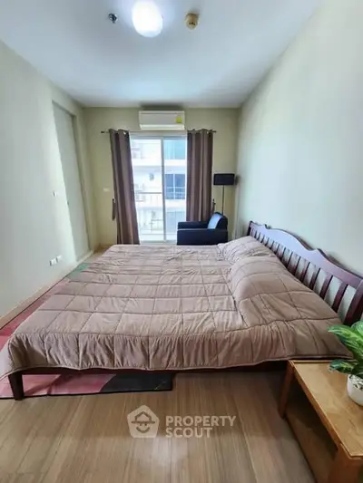 Spacious bedroom with large bed and balcony view in modern apartment