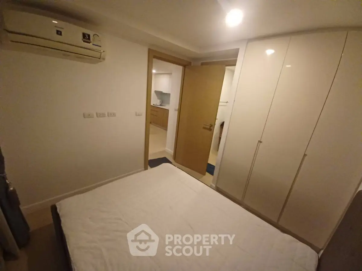 Cozy bedroom with built-in wardrobe and air conditioning in modern apartment.