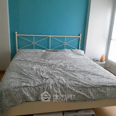Cozy bedroom with stylish bed and vibrant blue accent wall