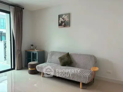Modern living room with stylish sofa and large window offering natural light.