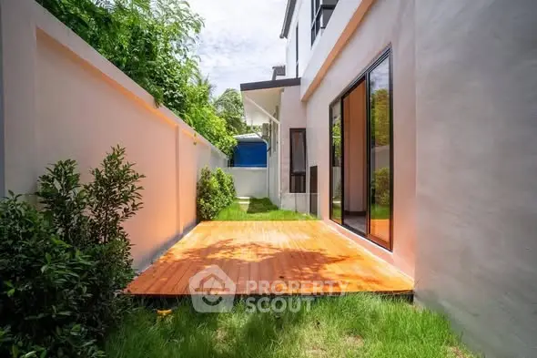 Charming backyard with wooden deck and lush greenery in modern home