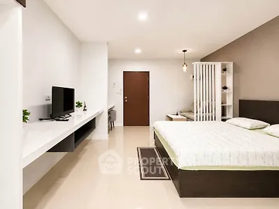 Modern bedroom with minimalist design, featuring a sleek TV console and cozy bed setup.