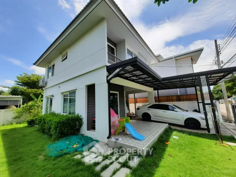 Charming two-story house with carport and lush green lawn in a serene neighborhood.