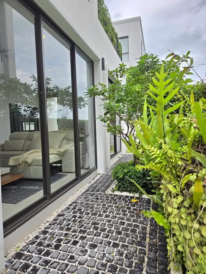 Modern home exterior with lush garden and large glass windows