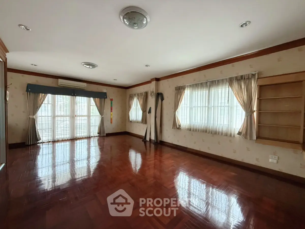 Spacious empty living room with hardwood floors and large windows