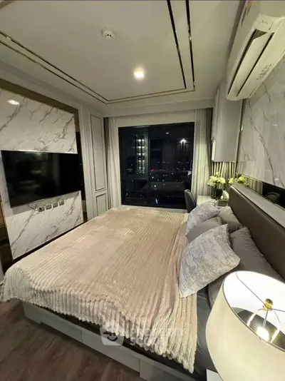 Luxurious bedroom with modern decor and city view, featuring elegant lighting and plush bedding.