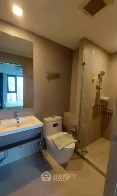 Modern bathroom with glass shower and sleek fixtures in a contemporary apartment.