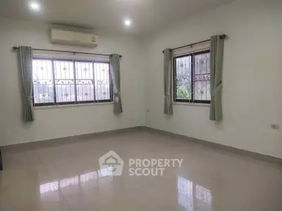 Spacious empty room with large windows and air conditioning, perfect for customization.