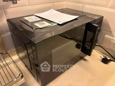Modern kitchen with sleek microwave oven on countertop, showcasing contemporary appliances.