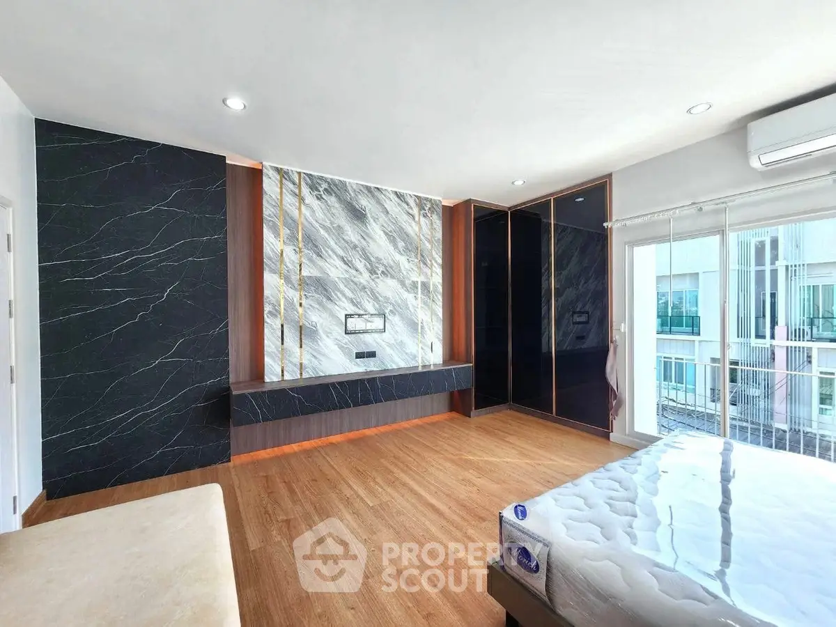 Spacious modern bedroom with elegant marble accent wall and large windows