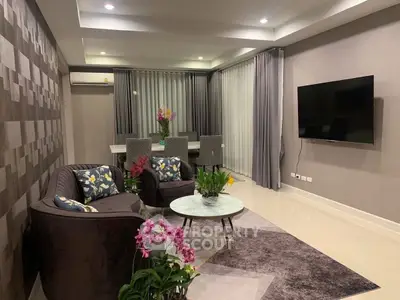 Modern living room with stylish decor, featuring a wall-mounted TV and elegant furniture.