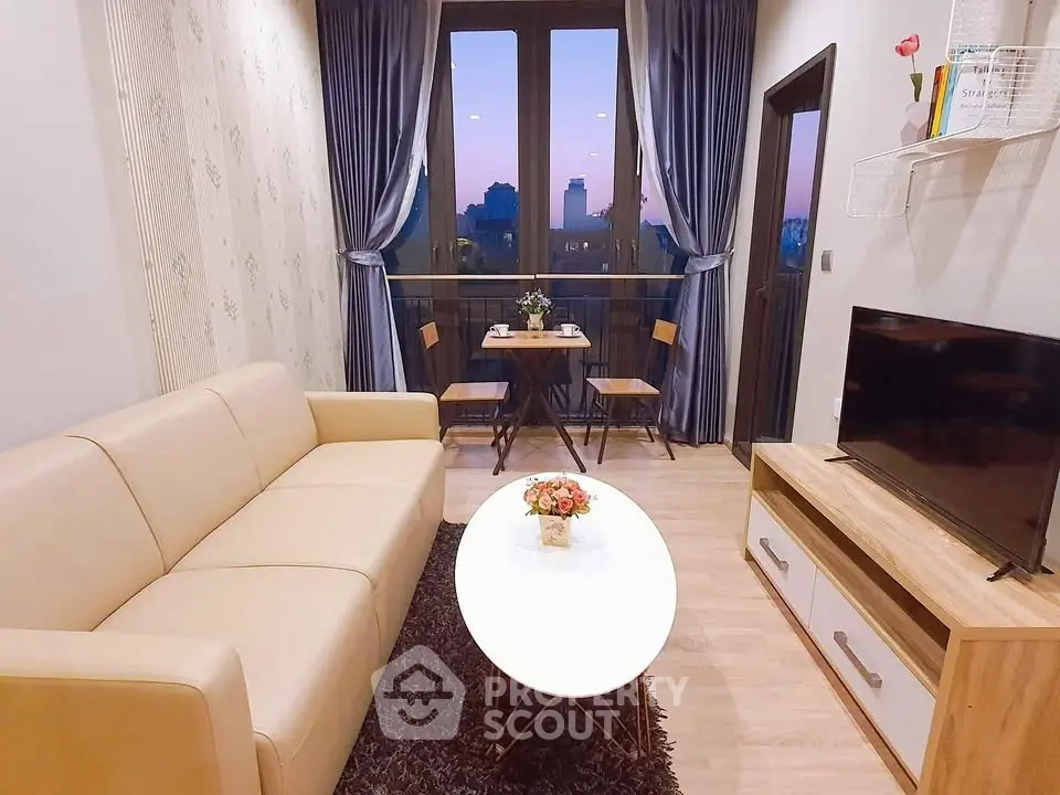 Charming living room with cozy seating and balcony view at sunset