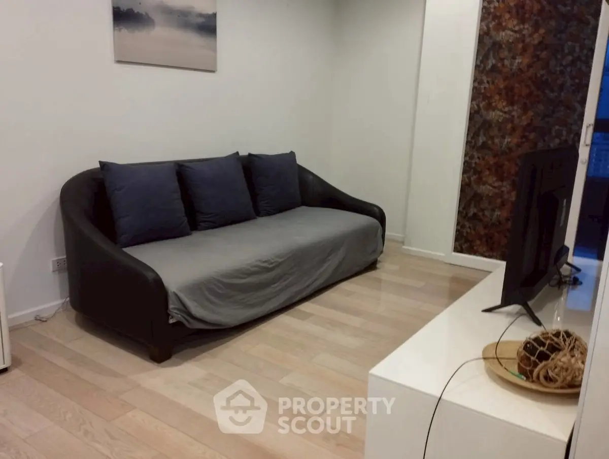 Cozy living room with modern sofa and TV, perfect for relaxation.