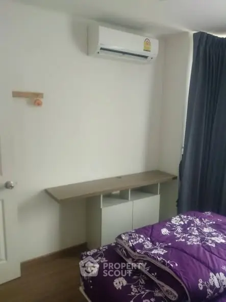 Cozy bedroom with air conditioning and stylish purple bedding