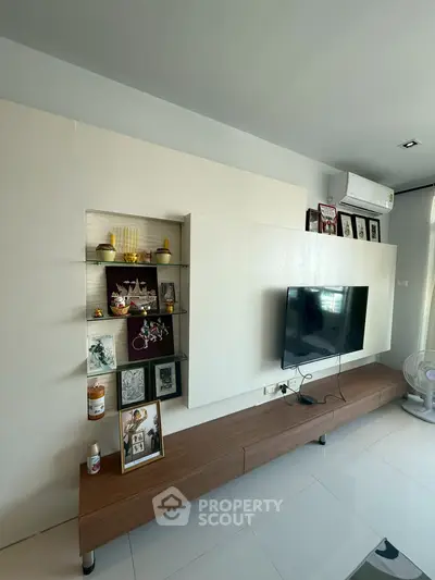Modern living room with sleek TV unit and decorative shelves