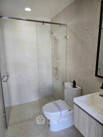 Modern bathroom with sleek shower and contemporary fixtures in a stylish real estate property.