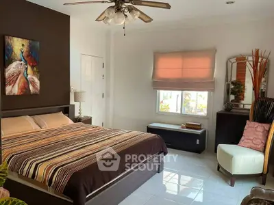 Spacious bedroom with modern decor and natural light, featuring a comfortable bed and stylish furnishings.