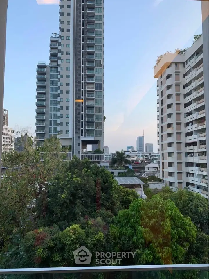 Stunning urban view from a high-rise apartment showcasing lush greenery and modern architecture.