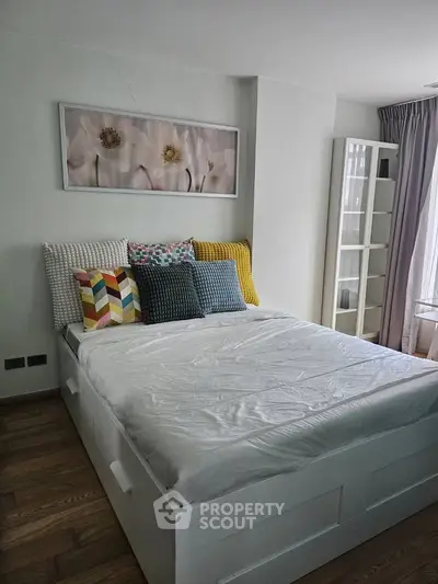 Modern bedroom with stylish decor and ample natural light, featuring a cozy bed and elegant furnishings.
