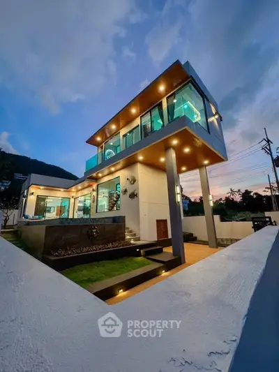 Stunning modern two-story house with illuminated exterior and scenic sunset view.