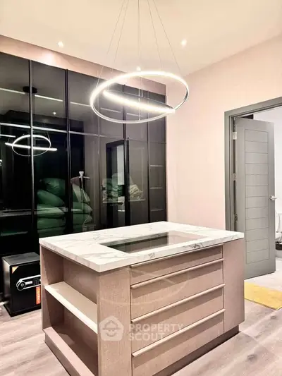 Modern kitchen with sleek island and stylish lighting in contemporary apartment.