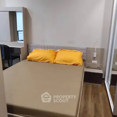 Cozy bedroom with modern furnishings and wooden flooring, featuring a comfortable bed and mirrored wardrobe.