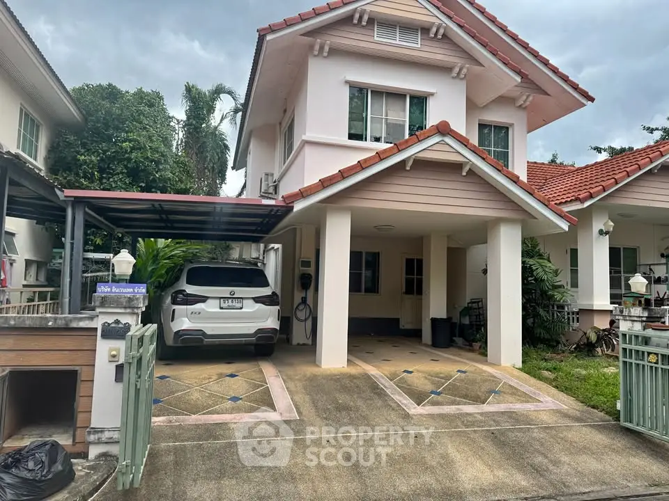 Charming two-story house with carport and lush greenery in a serene neighborhood.