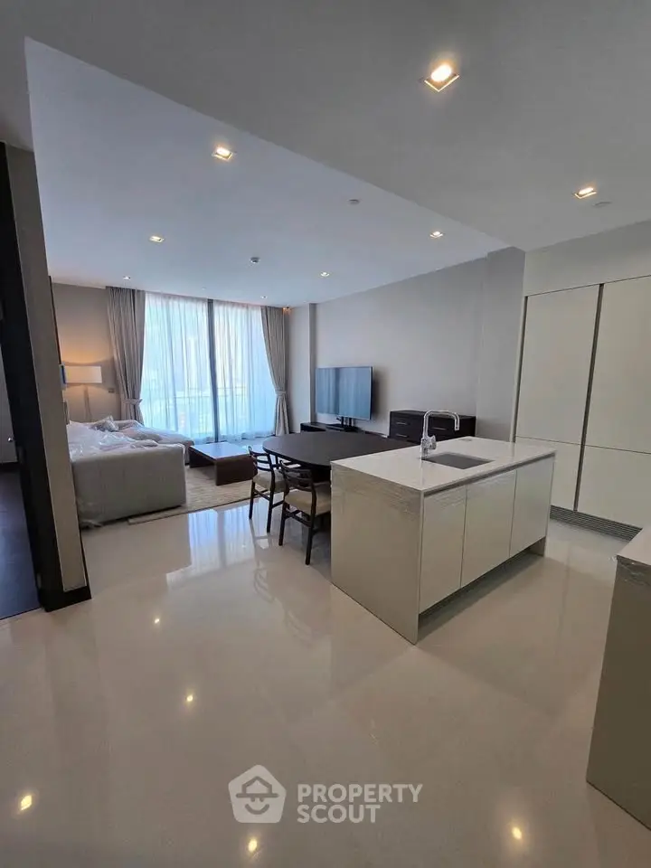 Modern open-plan living room with sleek kitchen and large windows in luxury apartment.