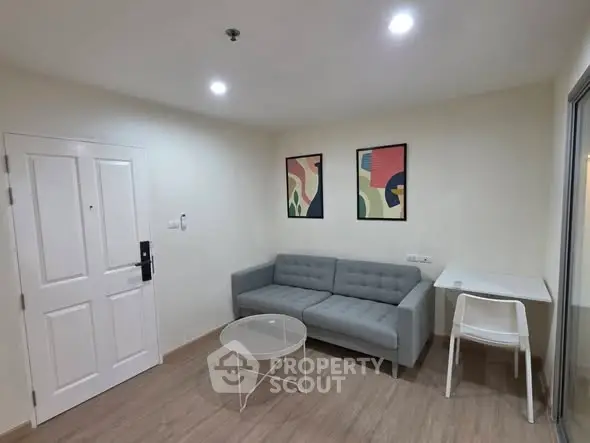 Modern living room with gray sofa, abstract art, and minimalist decor