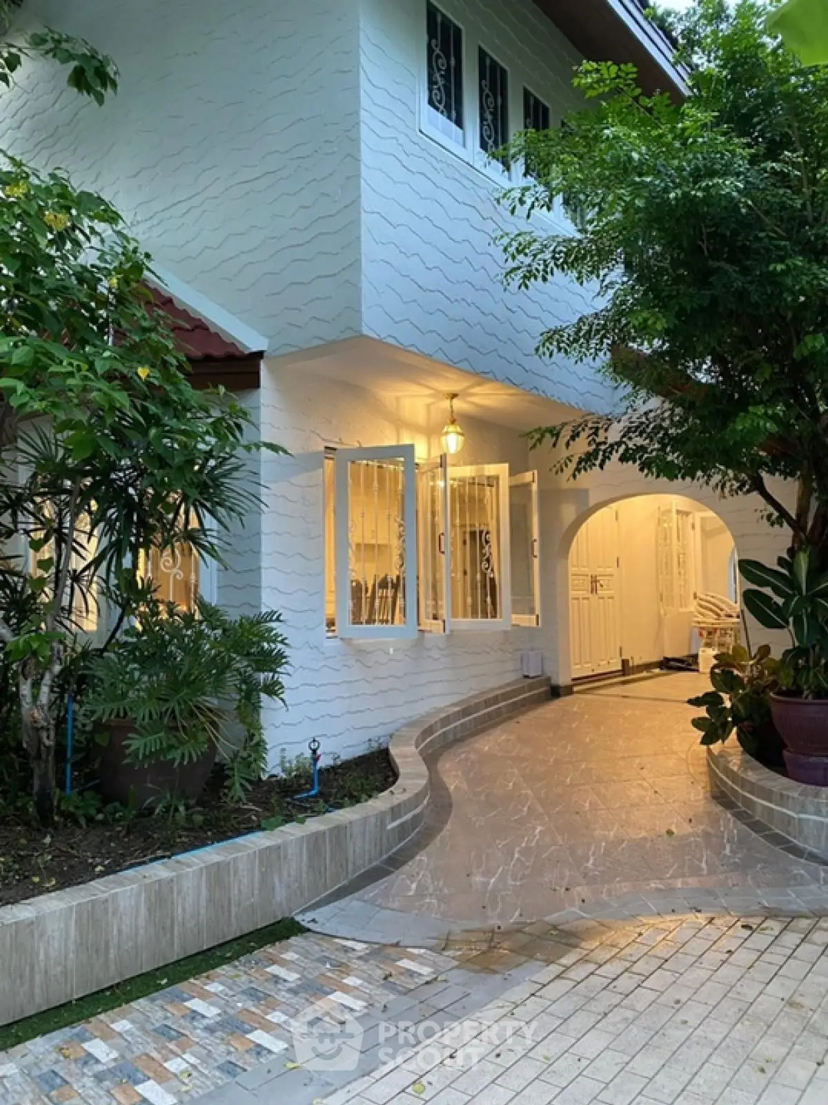 Charming white house with elegant entrance and lush greenery