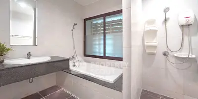 Modern bathroom with bathtub and shower, featuring sleek design and neutral tones.