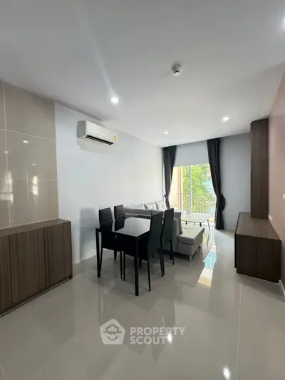 Modern living room with sleek furniture and natural light from balcony