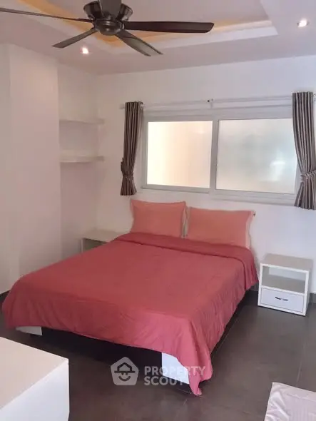 Cozy bedroom with modern ceiling fan and stylish decor, perfect for relaxation.