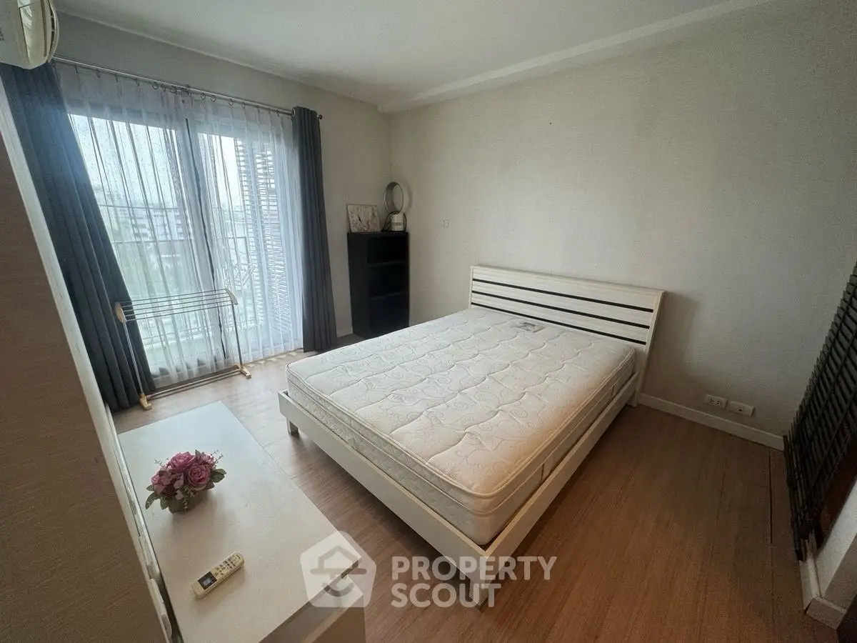 Cozy bedroom with natural light, featuring a comfortable bed and elegant decor.