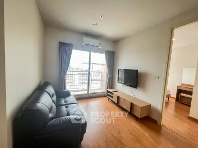Modern living room with balcony view, featuring sleek furniture and natural light.