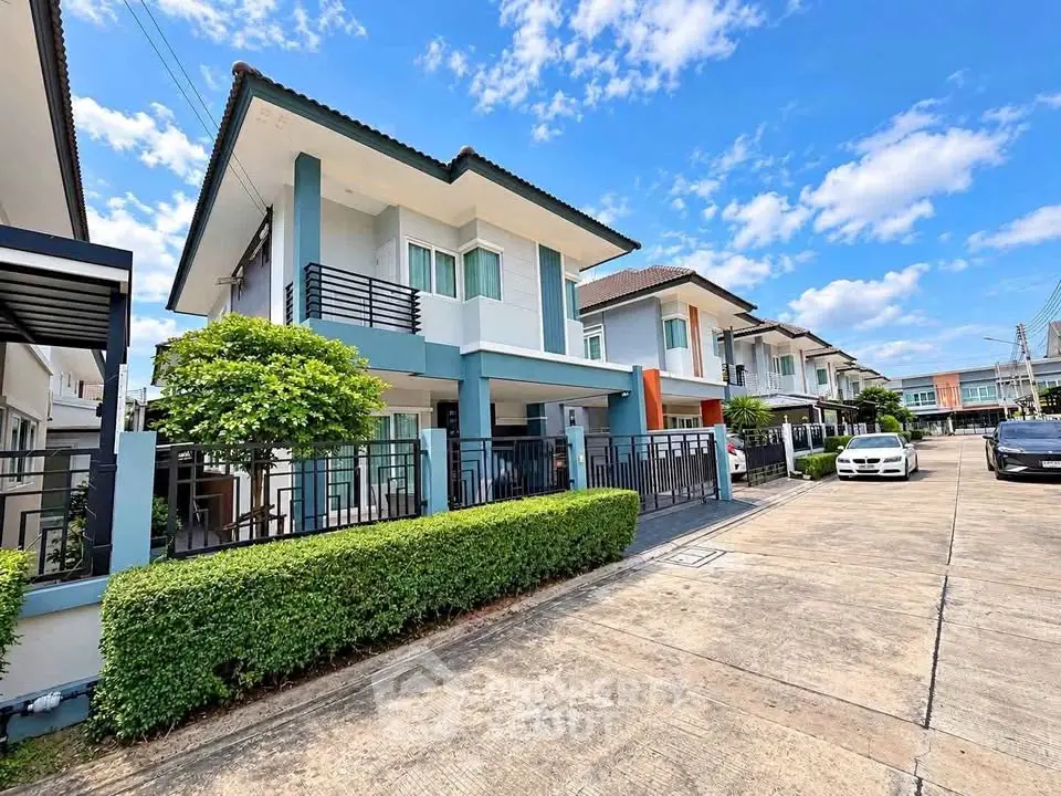 Modern two-story house with a sleek design in a suburban neighborhood, featuring a well-maintained front yard and driveway.