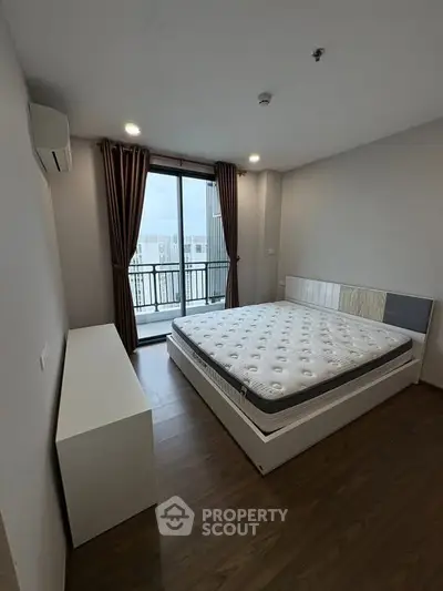 Modern bedroom with balcony access and stylish decor in a high-rise apartment.