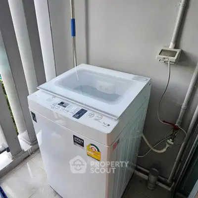 Modern washing machine on a balcony with utility connections, ideal for urban living convenience.