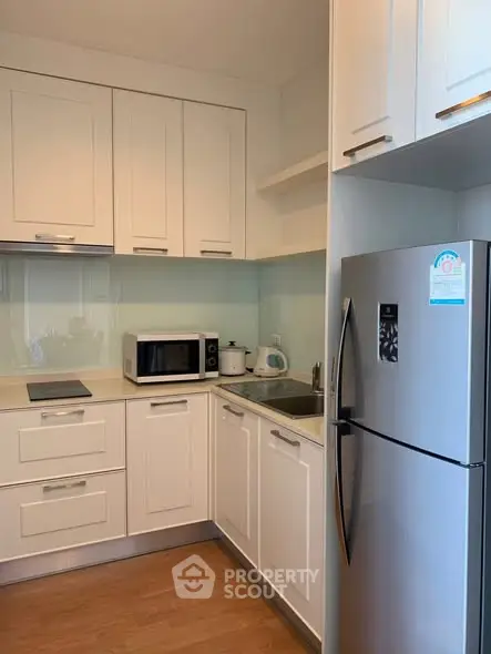 Modern kitchen with sleek white cabinets and stainless steel appliances
