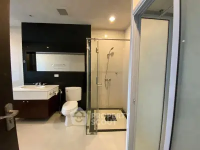 Modern bathroom with glass shower and sleek fixtures in a contemporary apartment.