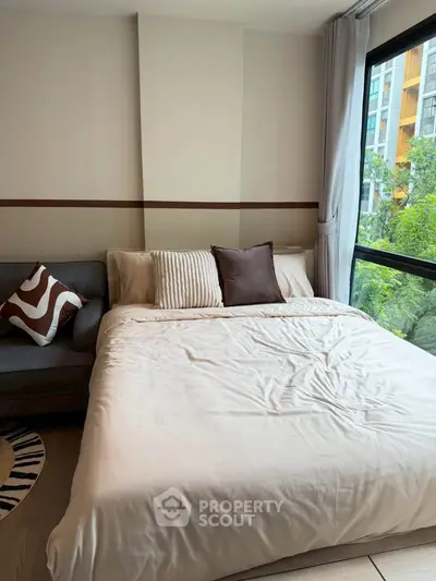 Cozy bedroom with large window and stylish decor in modern apartment
