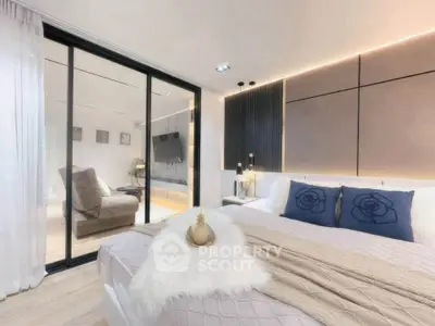Luxurious modern bedroom with elegant decor and sliding glass doors leading to a cozy living area.