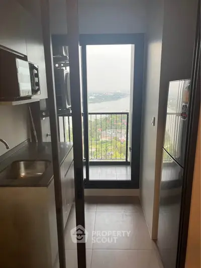 Compact kitchen with balcony view, modern appliances, and sleek design.