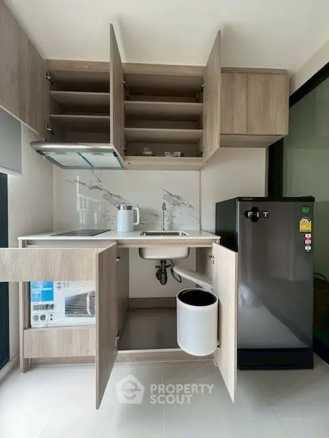 Modern compact kitchen with open cabinets and sleek appliances