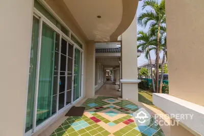 Charming residential entrance with colorful tiled walkway and lush greenery.